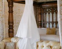 Wedding gown hanging from bed