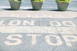 Cracked pavement at Union Market with painted text 'STOP DO NOT ENTER,' part of the rooftop’s industrial aesthetic