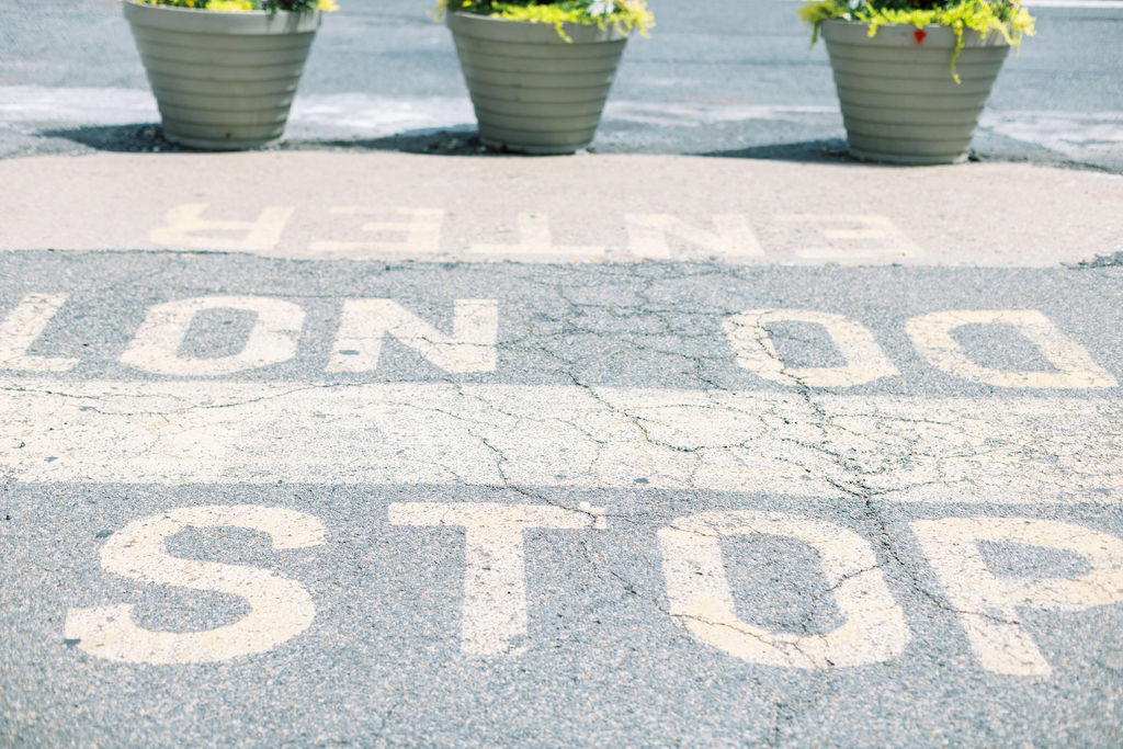 Cracked pavement at Union Market with painted text 'STOP DO NOT ENTER,' part of the rooftop’s industrial aesthetic