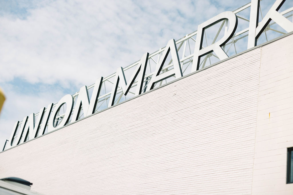 Exterior view of Union Market in Washington, D.C., featuring the iconic rooftop sign against a blue sky