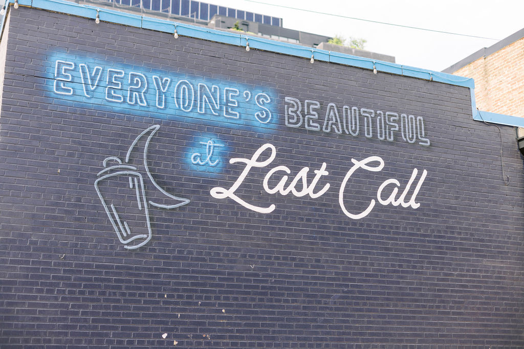 Wall mural with moon and martini graphic reading 'Everyone’s Beautiful at Last Call' near Union Market rooftop venue