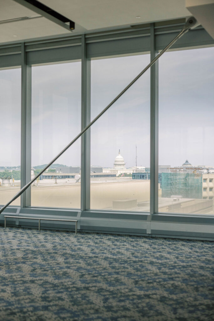 U.S. Capitol dome seen through tall glass windows from the International Spy Museum ballroom.
