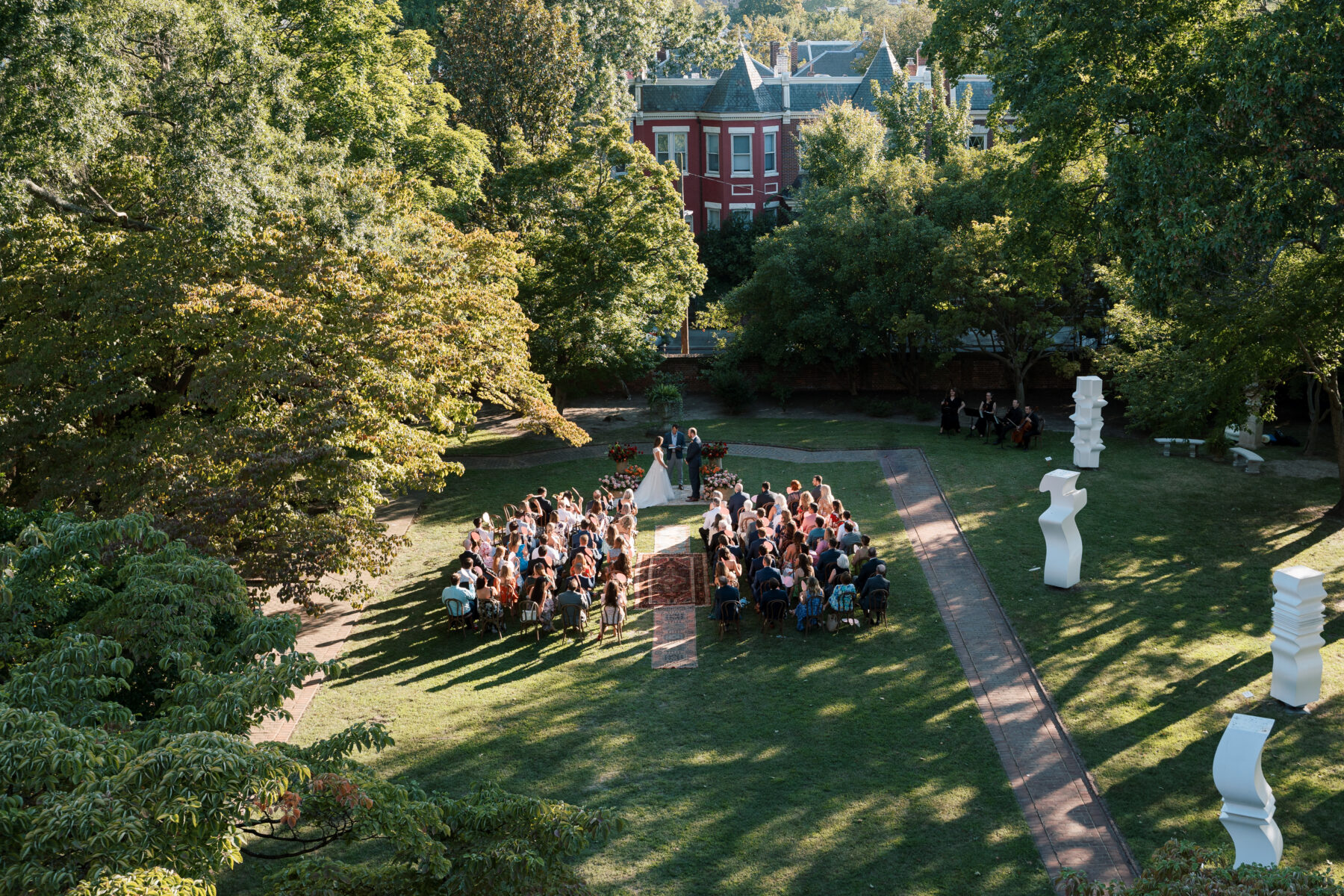 Aerial view of outdoor wedding ceremony at The Branch Museum in Richmond, Virginia, with guests seated in the garden during the vows