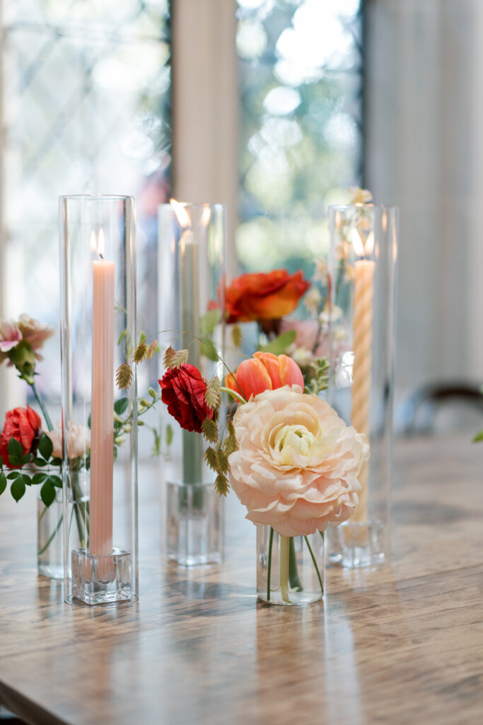 Colorful twisted, taper candles and fall wedding florals in glass bud vases at The Branch Museum reception