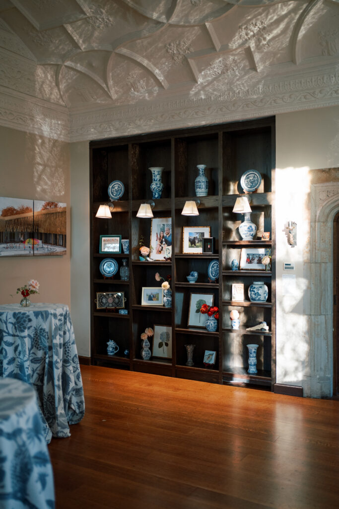 Styled wedding shelving display at The Branch Museum in Richmond featuring blue-and-white chinoiserie, heirloom decor, and framed family photos.