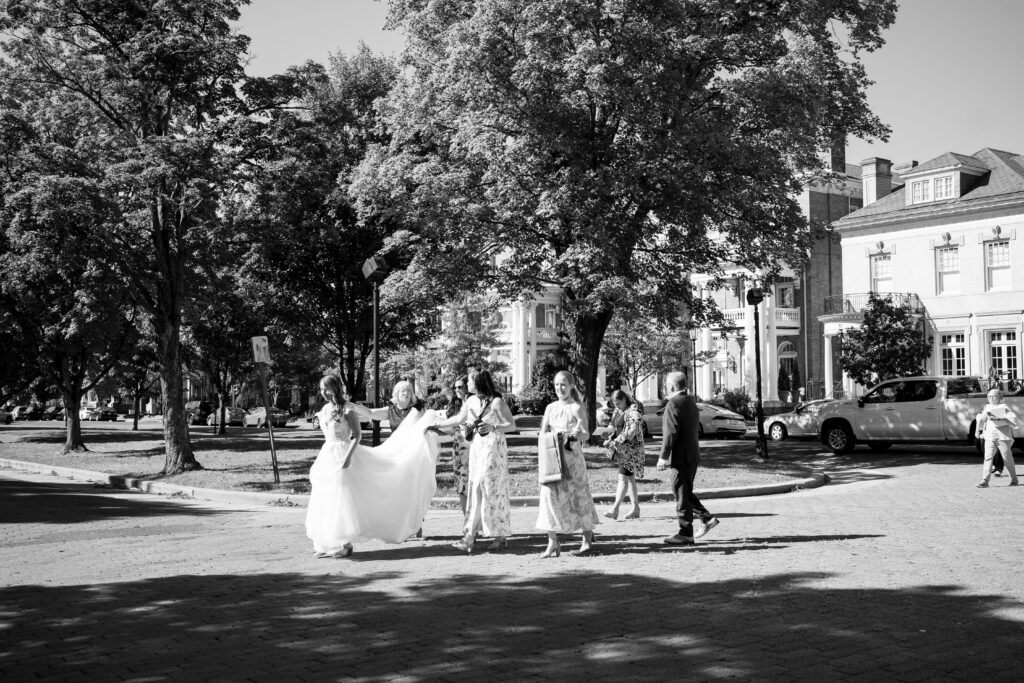 Bride walks across the Monument Avenue in Richmond VA with her bridesmaids. Branch Museum Wedding.