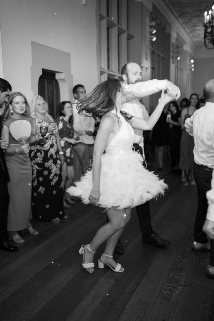 Bride dancing in feathered reception dress at The Branch Museum in Richmond, Virginia