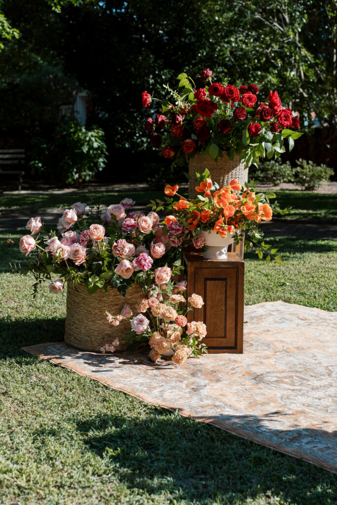 Vibrant wedding floral installation with roses and seasonal blooms at The Branch Museum garden ceremony. Fall wedding Richmond Virginia.
