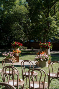 Fall garden ceremony setup at The Branch Museum in Richmond, Virginia, featuring floral arrangements and vintage rug aisle with chairs arranged for guests.