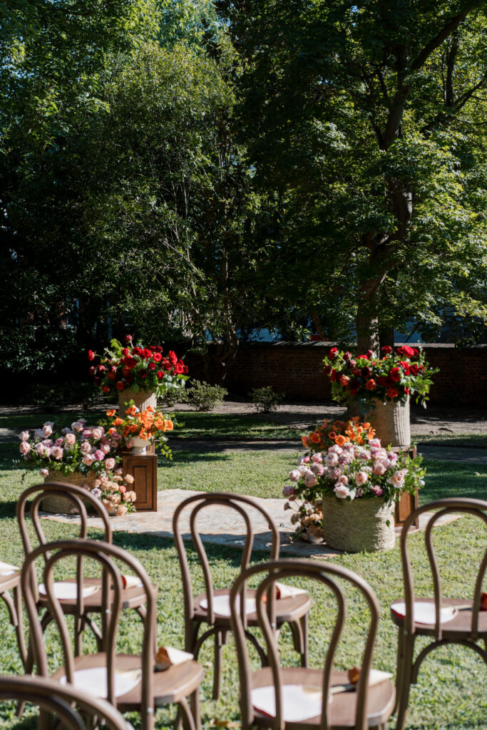 Fall garden ceremony setup at The Branch Museum in Richmond, Virginia, featuring floral arrangements and vintage rug aisle with chairs arranged for guests.