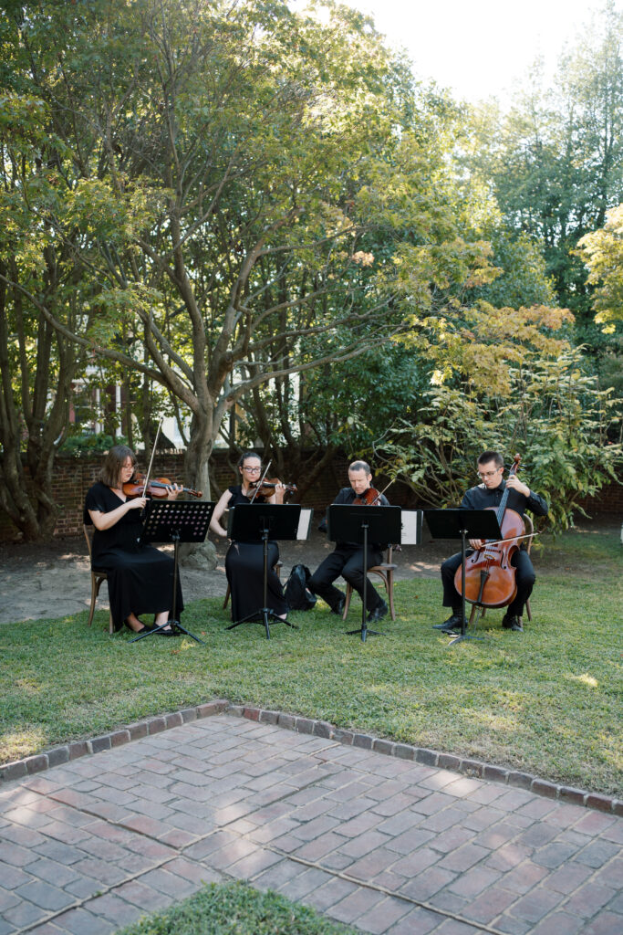 String quartet performing live music during an outdoor wedding ceremony at The Branch Museum, Richmond. Richmond va wedding planner.