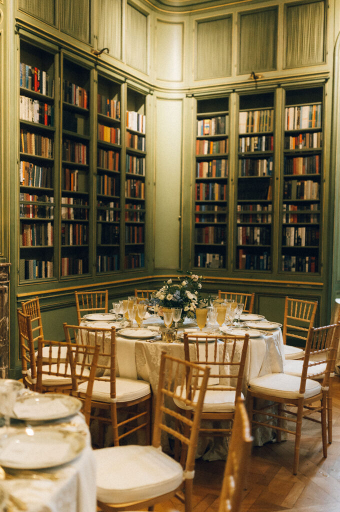 Reception table set with gold-rimmed chargers, crystal glassware, and floral centerpiece inside the Meridian House library. Fall wedding Meridian House Washington DC. 