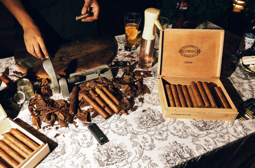 Cigar roller crafting hand-rolled cigars at a wedding cigar bar setup on toile linen at Meridian House in Washington, D.C.