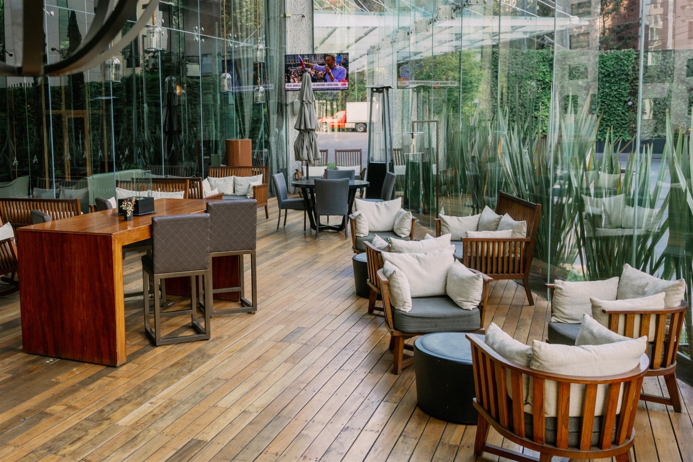 A restuarant at Live Aqua in Mexico City surrounded by glass and greenery