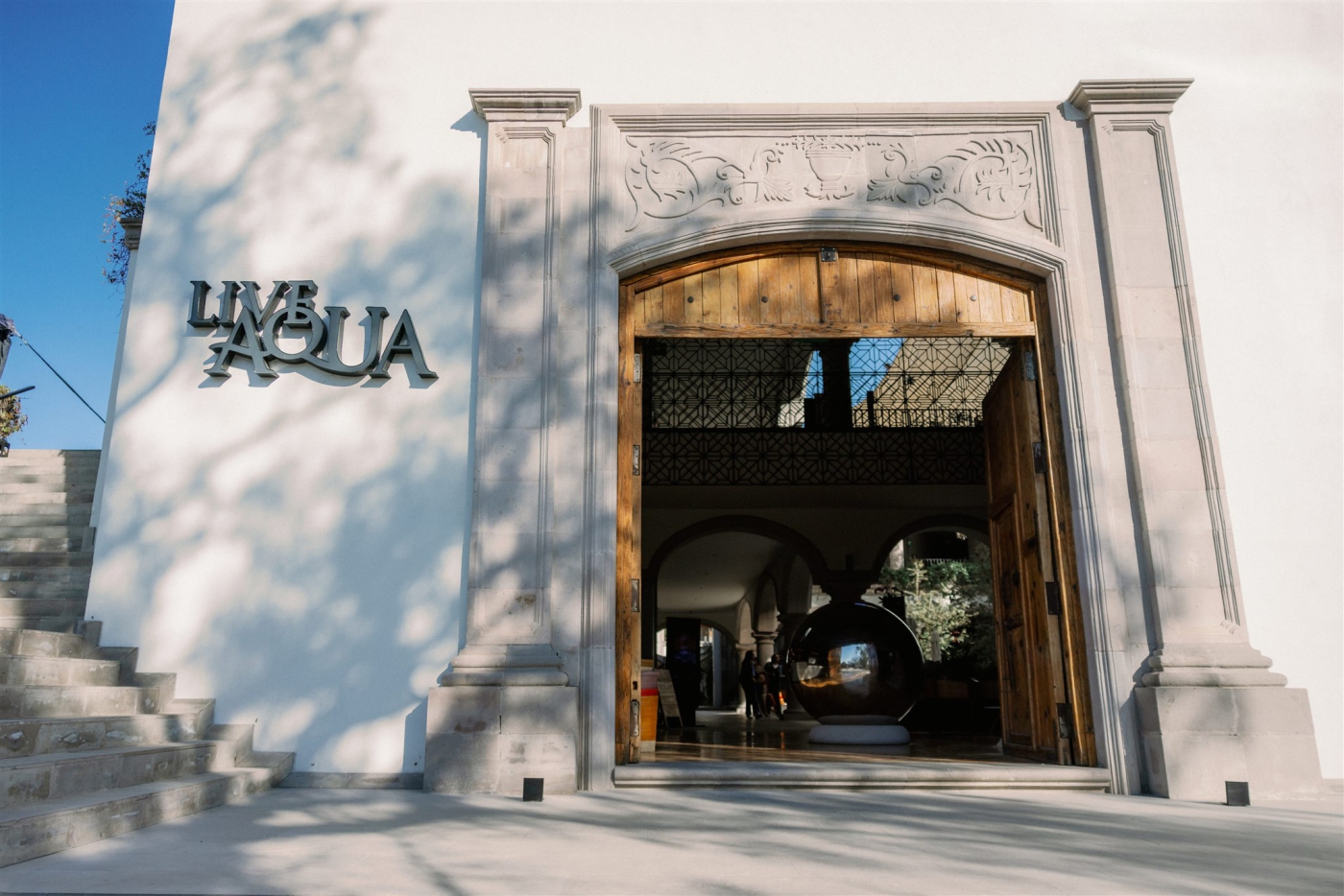 The entrance to a large white hotel framed with grey stone columns