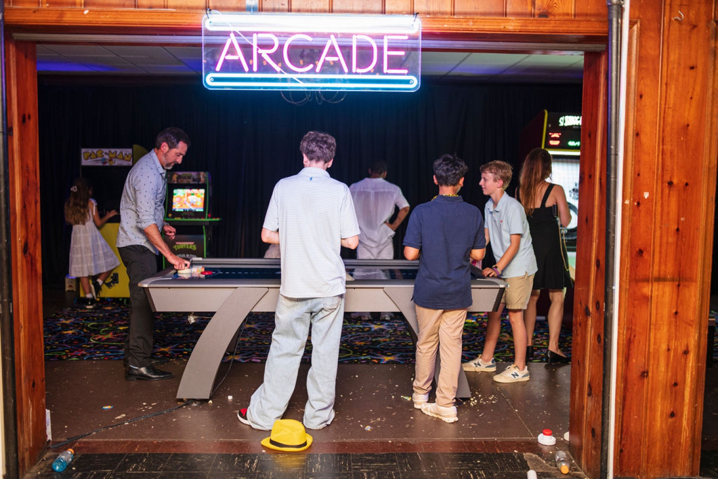 Teens playing air hockey in an arcade-themed Bar Mitzvah