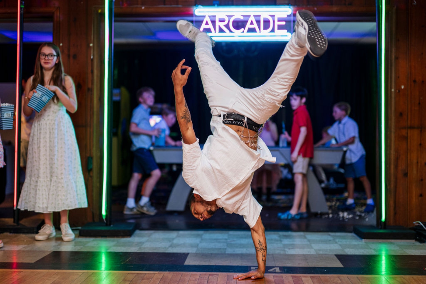 A man stands on his hands on the dance floor at a Bar Mirzvah