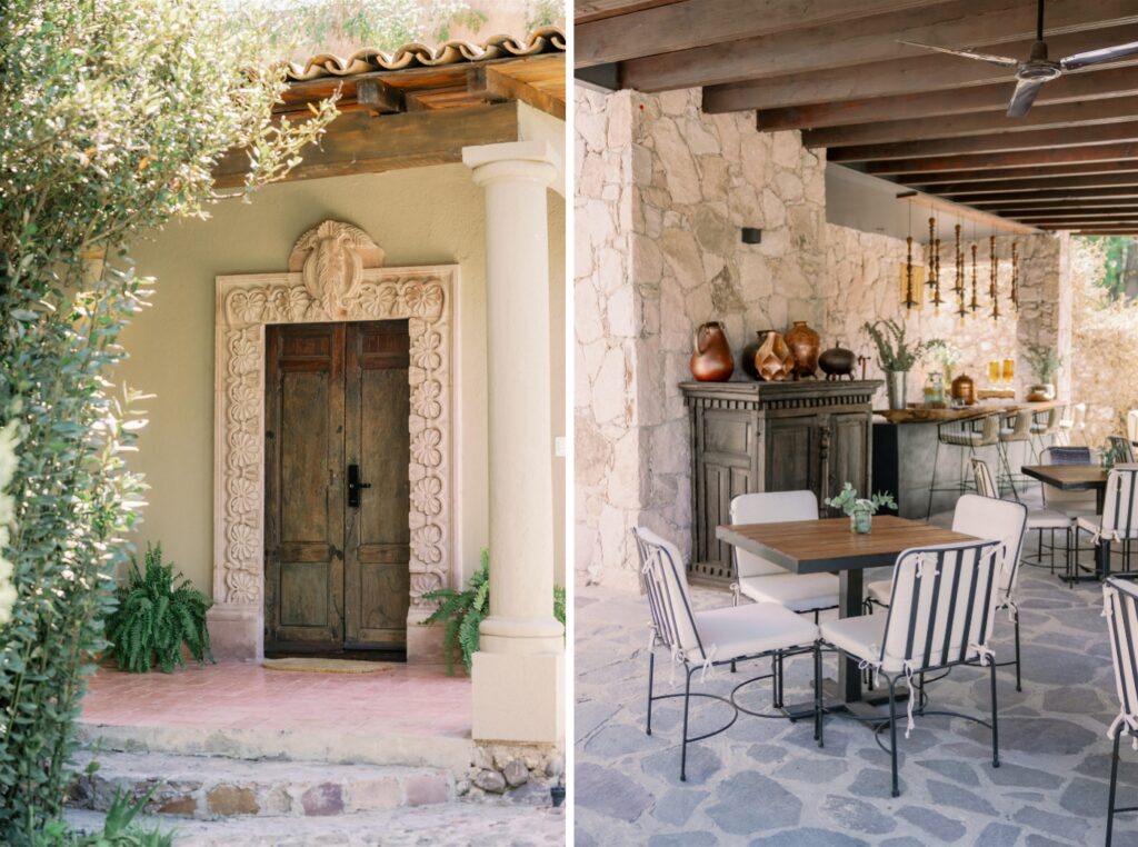 An outdoor stone patio with tables and chairs covered by an awning with a ceiling fan